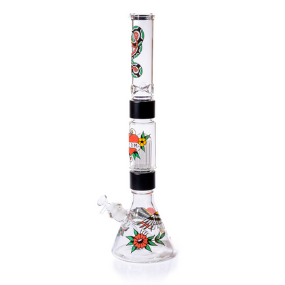 Side profile view of the Prism Inked Beaker Double Stack modular pipe, showcasing the full assembled height. The system features a clear beaker base with eagle and flower tattoo graphics, connected by black anodized aluminum Halo Connectors to the large Big Tree Percolator. A second black aluminum halo connects to the standard clear mouthpiece with a snake decal. This high-performance dual chamber apparatus offers superior smoke cooling and diffusion. The best gift for tattoo lovers.